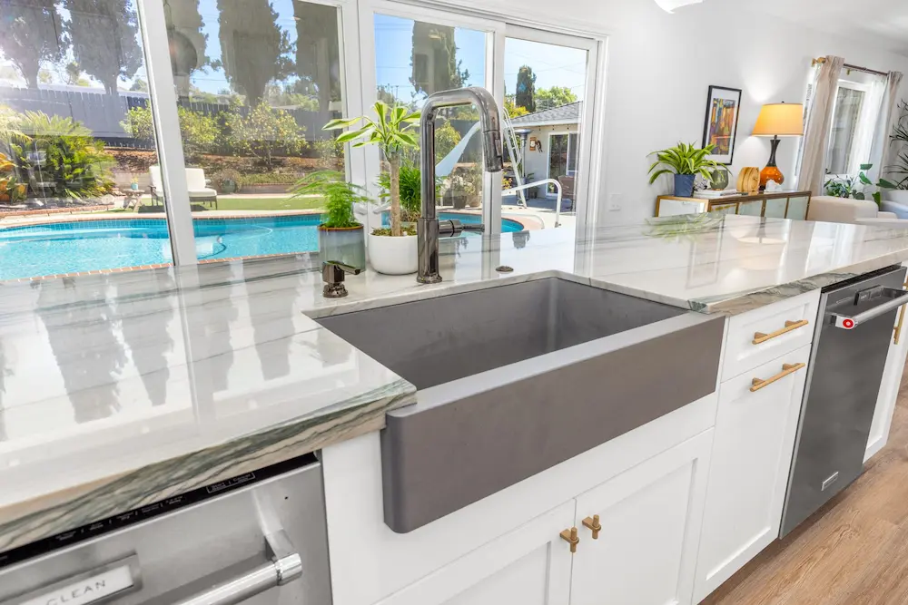 San Diego kitchen remodel with gray farmhouse sink, marble countertop and pool view