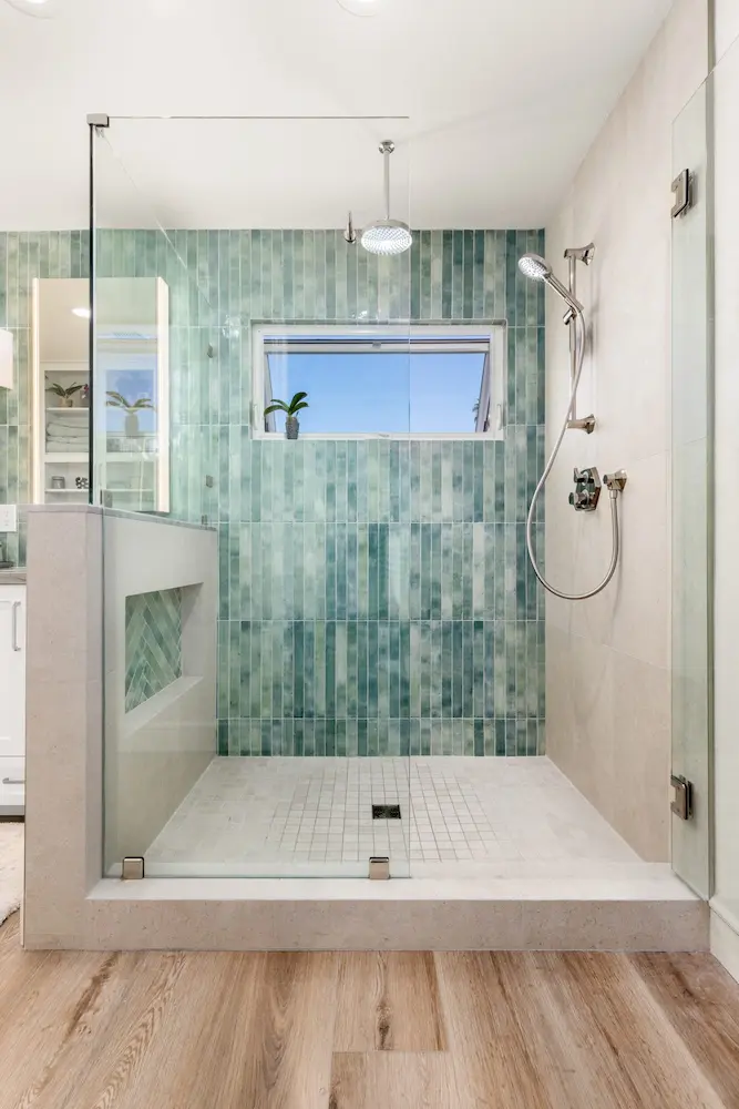 Bathroom remodel with walk-in shower, green vertical tile and wood-look flooring