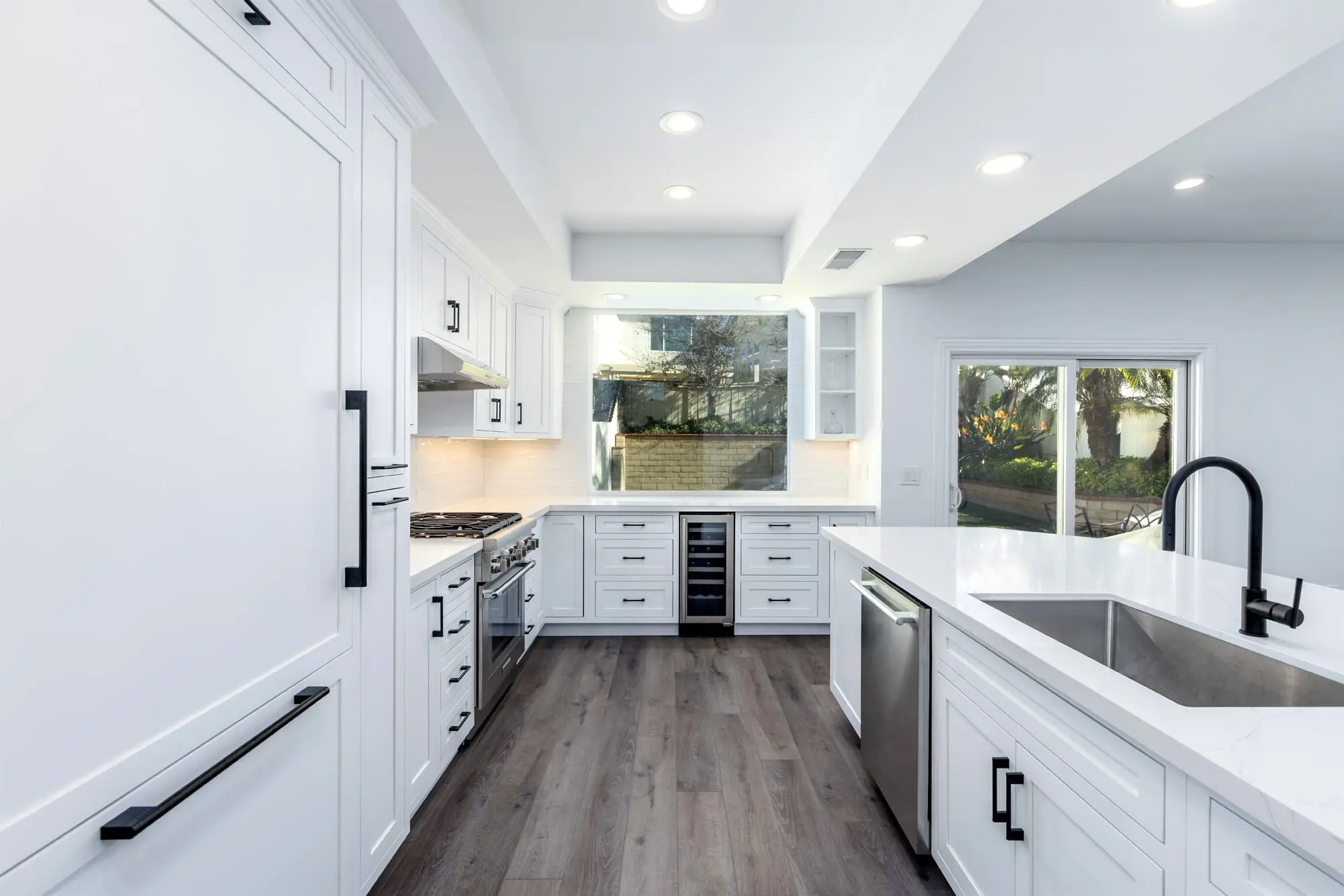 Bright white shaker kitchen with chrome appliances after Escondido remodel
