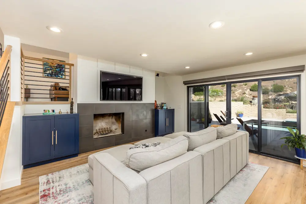 Family room with sliding doors to the pool area and ultra-modern fireplace